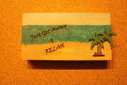 Sign "Just Get Away & Relax" with a beach scenery and palm tree