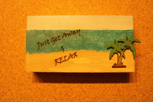 Sign "Just Get Away & Relax" with a beach scenery and palm tree