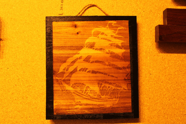 Decorative Sign with engraved Ghost Ship and black boarders that's 8 inches square.