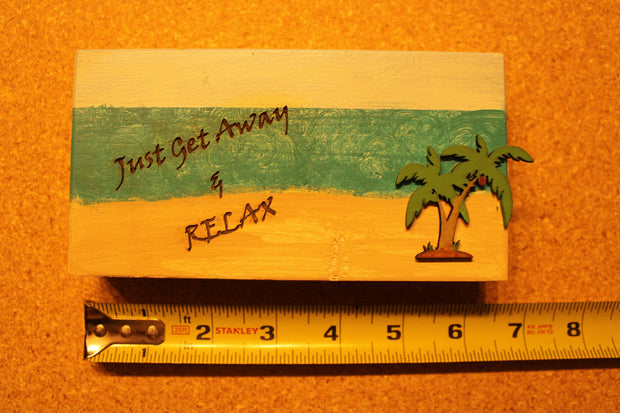 Sign "Just Get Away & Relax" with a beach scenery and palm tree