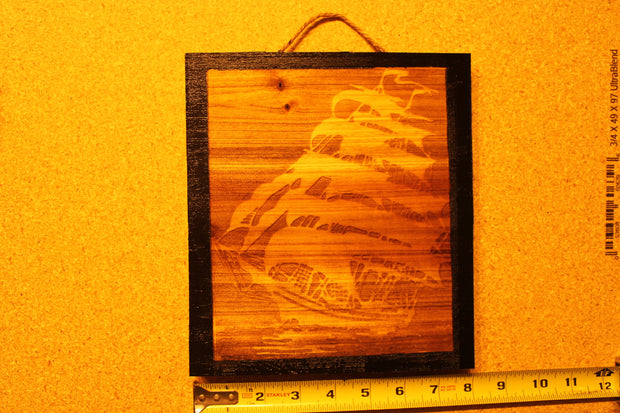 Decorative Sign with engraved Ghost Ship and black boarders that's 8 inches square.