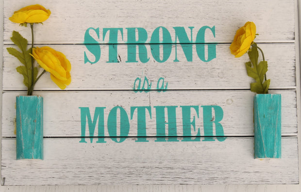 Decorative Sign Strong as a Mother and has two vases with flowers on each side